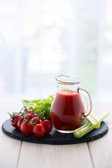 Tomato juice in a glass jar on wooden table.
