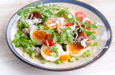 Fresh salad with fish, eggs and tomatoes in plate.