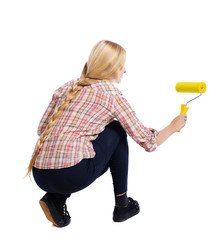Back view of a girl who paints the paint roller. rear view people collection. backside view of...