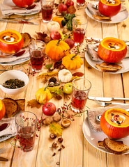 Festive table setting of pumpkin soup and drinks