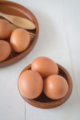 Egg in a wooden bowl on wooden table white. Chicken Egg. Top view with copy space