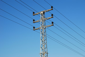 Electrical pylon and wires on blue sky background