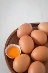 Egg in a wooden bowl on wooden table white. Chicken Egg. Top view with copy space