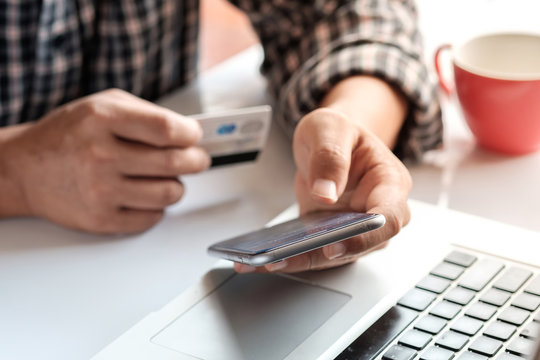 Online payment, Man's hands holding a credit card and using smart phone for online shopping