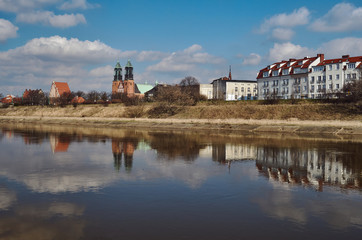 Urban landscape with river Warta, the cathedral towers and residential houses in Poznan.