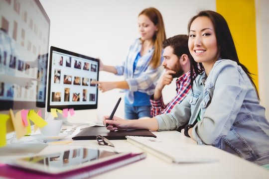 Businesswoman with coworkers at desk