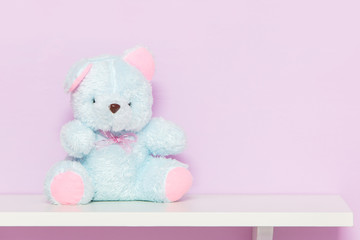 Blue teddy bear on shelf.