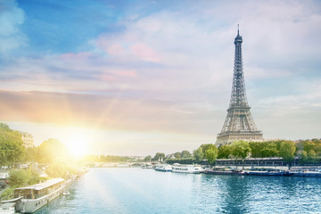 Romantic sunset background. Eiffel Tower with boats on Seine river in Paris, France.