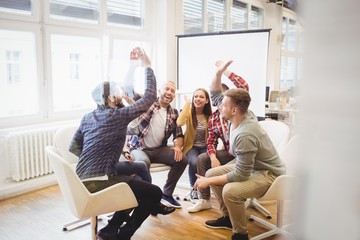 Excited creative business people giving high-five