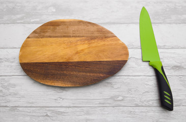 kitchen knife on an old cutting board on the wooden table