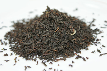 Dry black tea leaves isolated on white background.