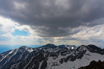 Obraz premium High snowy mountains under blue cloudy sky