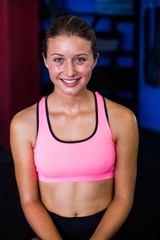 Fototapeta na wymiar Portrait of fit smiling woman in gym