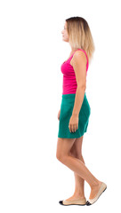 Fototapeta premium back view of walking woman. beautiful girl in motion. backside view of person. Rear view people collection. Isolated over white background. Girl in a green skirt passes.