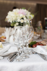 Wedding decoration with wine glasses, flowers and cutlery