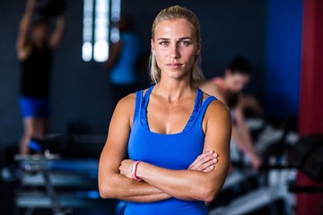Fototapeta na wymiar Portrait of serious woman with arms crossed in gym