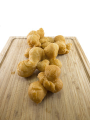 Deep-fried dough on wooden chopping board