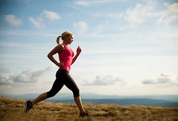 Photo sur Aluminium Jogging runner - woman runs cros country on a path in early autumn
