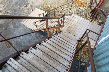 Wooden steps with rusty railing leading down from abandoned coal mine