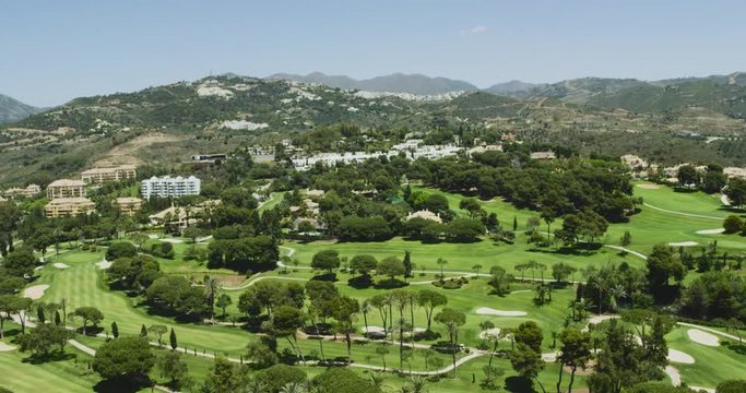 4K Helicopter aerial view flying over Marbella golf course near mountains. Spain 2016