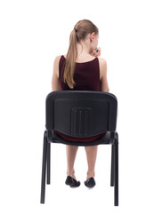 back view of young beautiful  woman sitting on chair.  girl  watching. Rear view people collection....