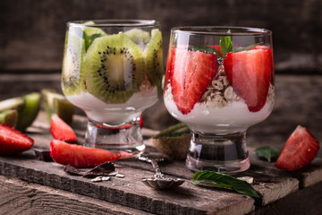 Healthy breakfast or morning snack with chia seeds granola, strawberries and kiwi, vegetarian food, diet and health concept