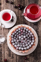 Tart with cherry and whipped cream on wooden vintage table