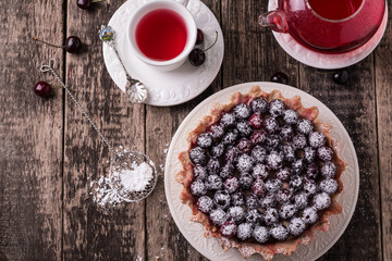Tart with cherry and whipped cream on wooden vintage table