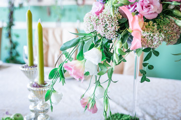 A bouquet of flowers on a stand with candles and decor for table decoration at weddings and celebrations