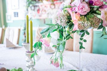 A bouquet of flowers on a stand with candles and decor for table decoration at weddings and celebrations