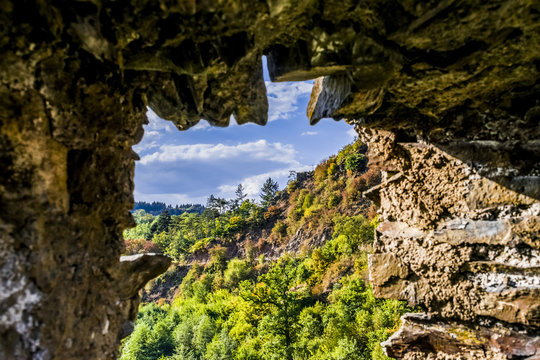 Autumn landscape. Autumn in the mountains. Autumn forest. The view from the loop-hole in the wall of an old castle. Eltz Castle in Germany.