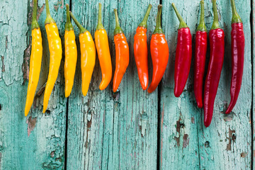 many vibrant colors on peppers , old wooden background