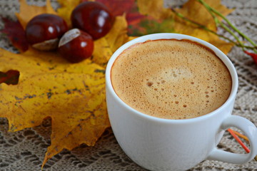 Cup of coffee with leaves and chestnuts