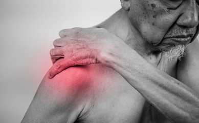 Naklejka premium senior man hand holding healthy arm and massaging he shoulder in