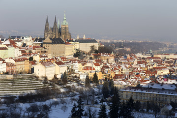 Obraz premium Snowy Prague City with gothic Castle in the sunny Day, Czech Republic