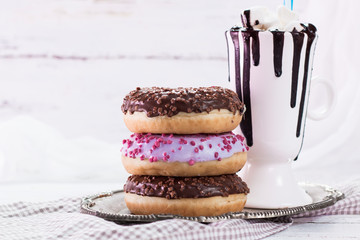 donuts and a cup of coffee with chocolate on a wooden table