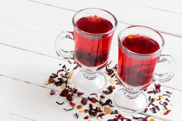 Fruit tea in a two glass cups on a white wooden background