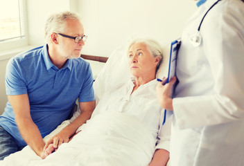 Obraz premium senior woman and doctor with clipboard at hospital