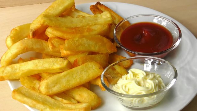 French fries with ketchup and mayonnaise. a potato chip is dipped in ketchup
