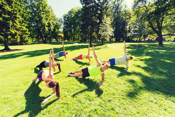 group of happy friends exercising outdoors
