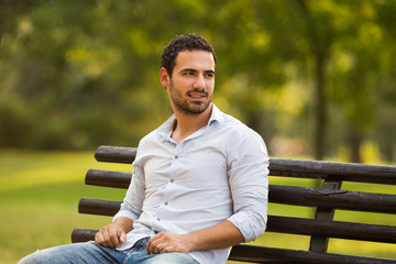 Young businessman enjoys sitting at the park.

