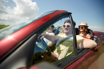 happy friends driving in cabriolet car