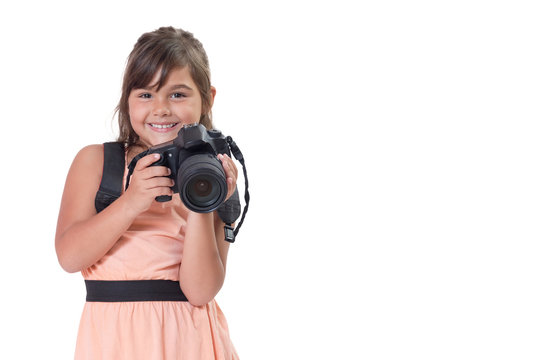 Smiling long hair little girl is holding SLR camera. All is isolated on the white background. All potential trademarks are removed.