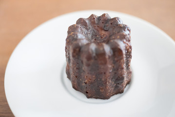 a bun glaze with chocolat on white dish