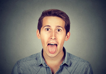 portrait of young man sticking out his tongue