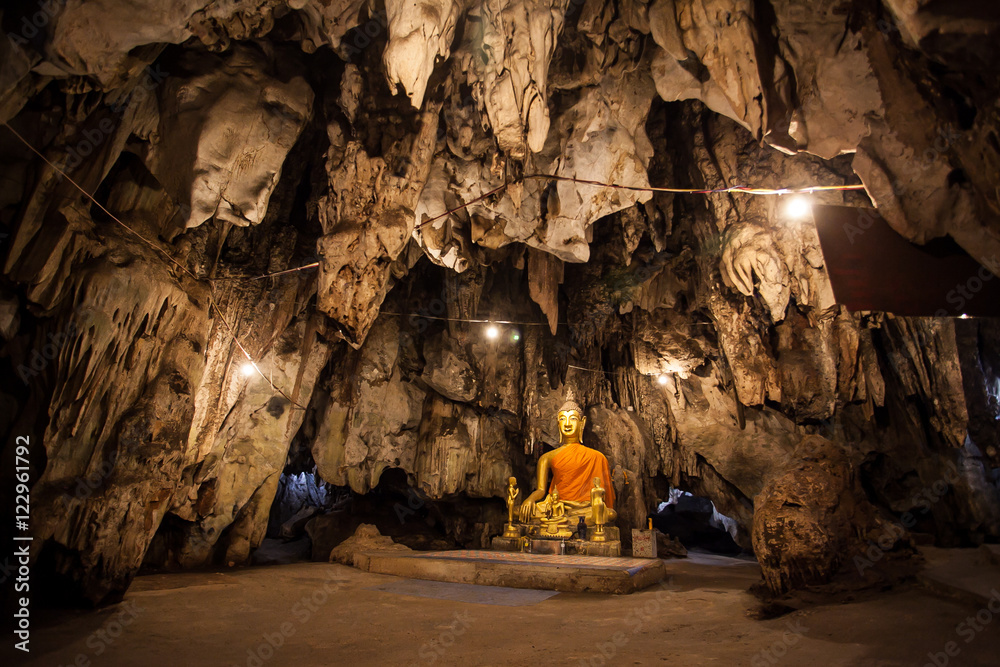 Wall mural the old ancient buddha statue in cave at wat tham khao pun, kanchanaburi province, thailand.