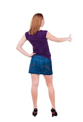 Back view of of young woman in jeans dress going thumb up. girl showing ok sign. isolated on white Rear view.Showing of positive emotions with OK sign concept .
