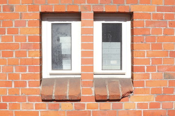 Schmale Kunststoffenster an Backsteinwand