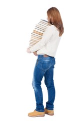 Naklejka premium A girl carries a heavy pile of books. back view. Rear view people collection. backside view of person. Isolated over white background.