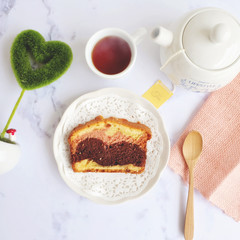 A slice of a home made chocolate-butter sponge cake and tea